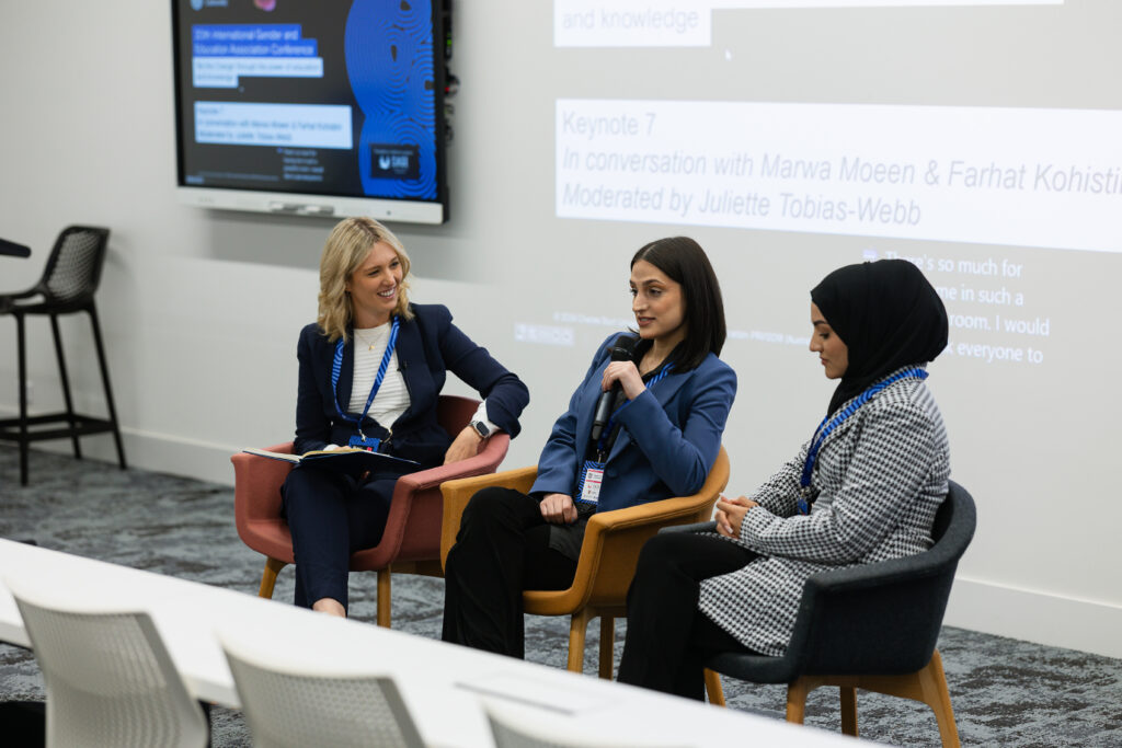 three people talk at a conference