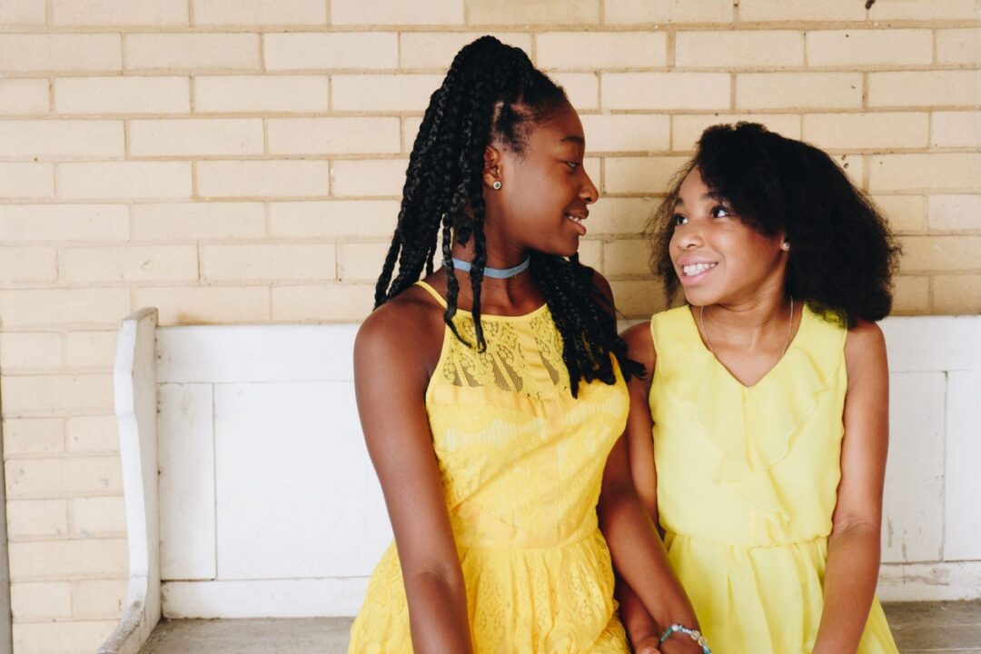 two smiling young Black girls smiling at each other