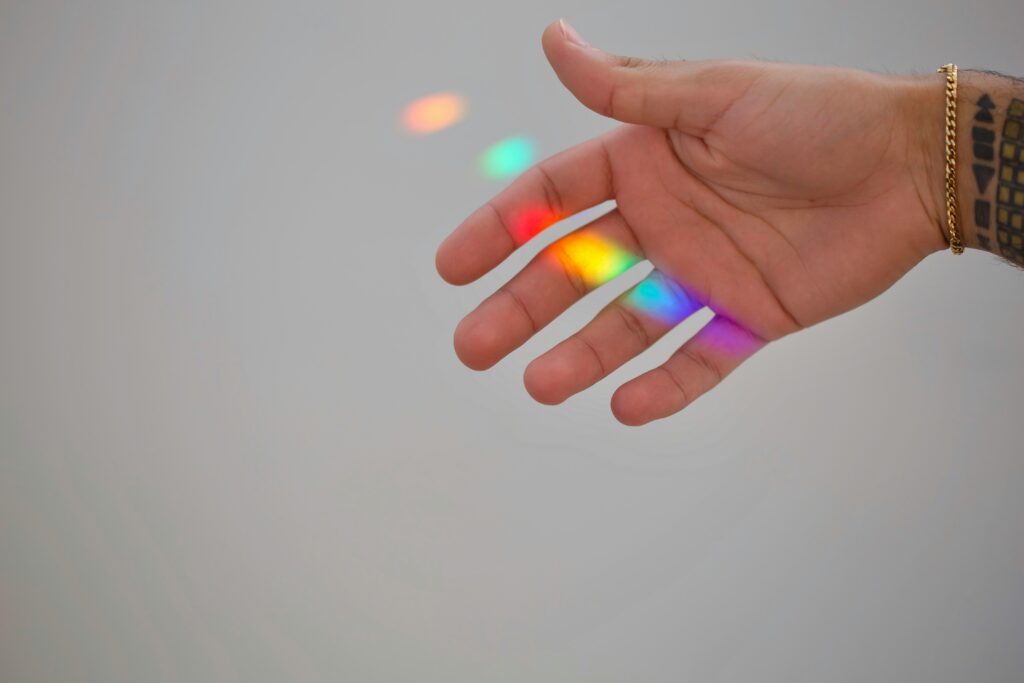 fair skinned hand with light refracting to make rainbow