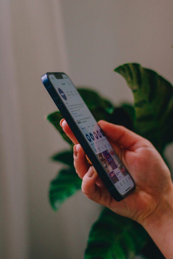 hand holds a phone showing a social media page